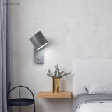 Rotatable cylinder wall sconce in a styled bedroom