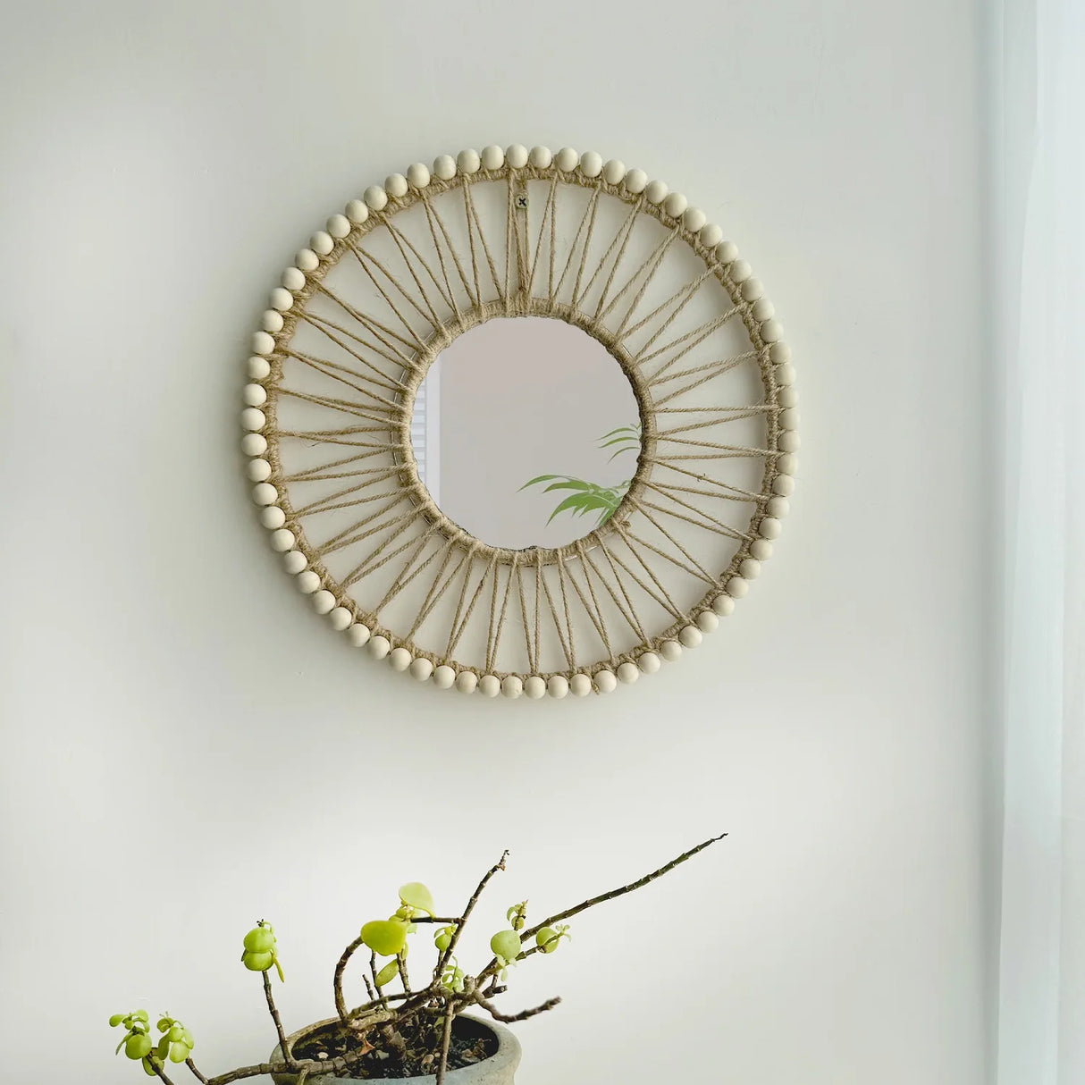Macrame decorative mirror displayed above entryway console