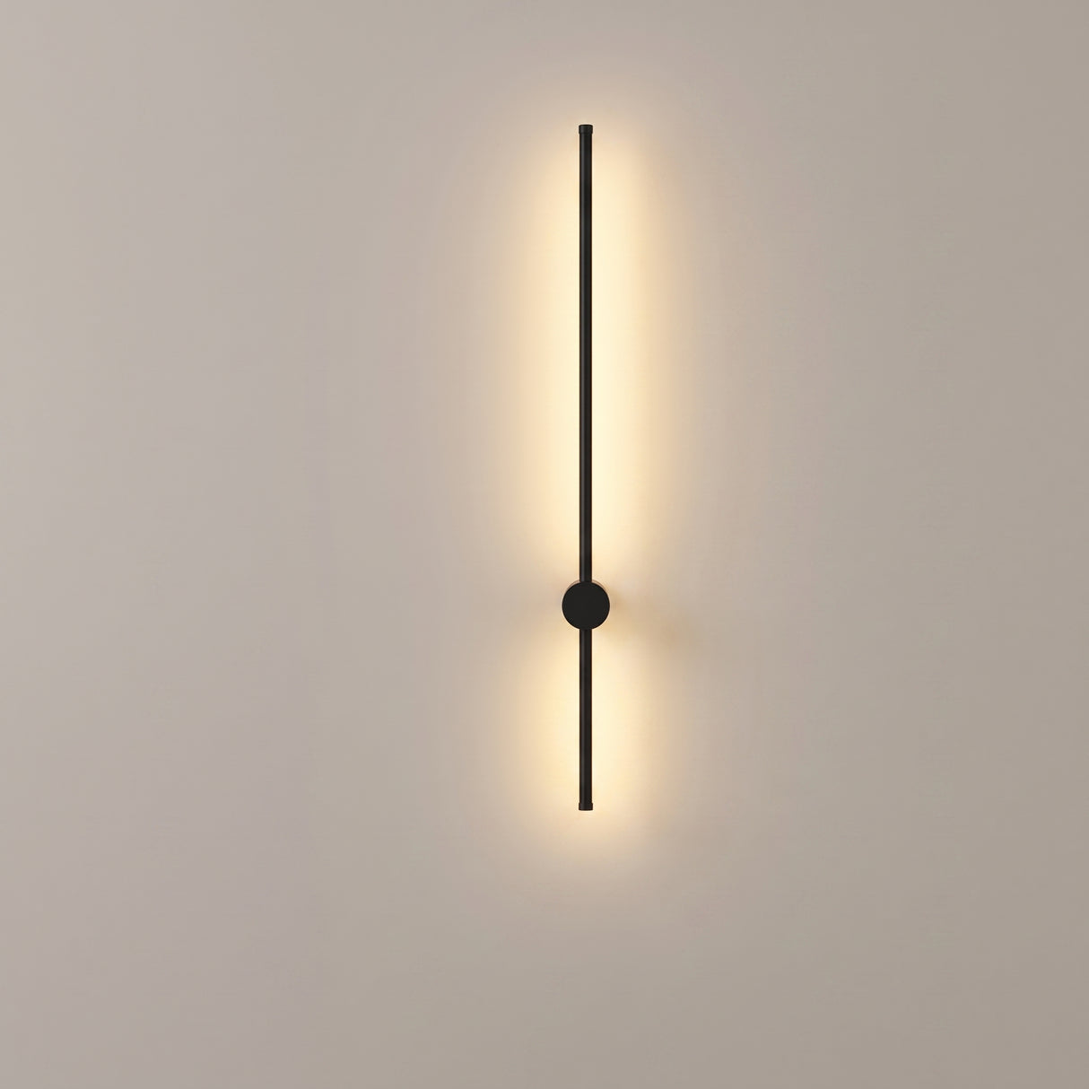 Matte black linear LED wall sconce mounted on a plain warm-grey studio wall