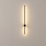 Matte black linear LED wall sconce mounted on a plain warm-grey studio wall