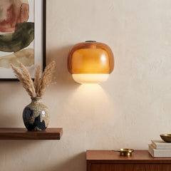 Two-tone amber and opal glass wall sconce mounted above a walnut console