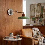 Adjustable swing arm wall lamp with green disc shade and chrome arm