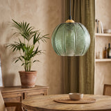 Green textured glass globe pendant with palm leaf ribbing and wooden cap in a boho dining room