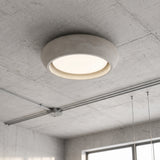 Rounded cement dome flush mount ceiling light with a warm recessed LED ring