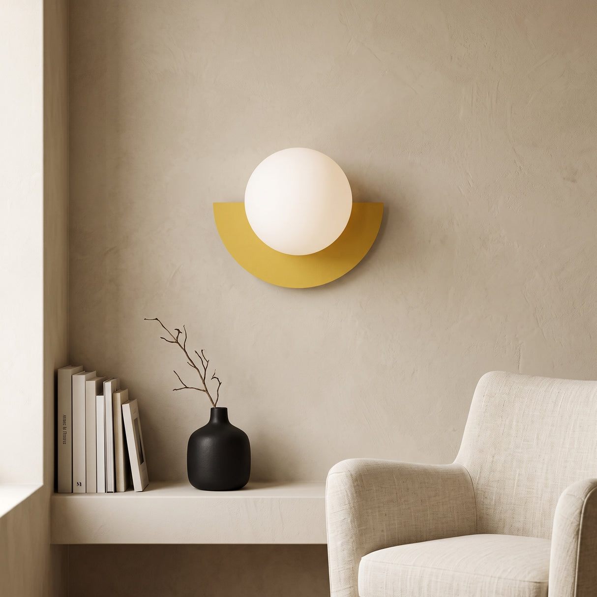 Yellow half moon wall sconce with frosted glass globe on a plaster wall