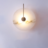 Backlit marble disc on a black arm showing a soft halo