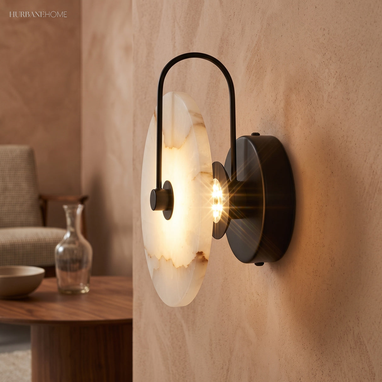Black arm marble sconce lit beside a wooden table and glass vase