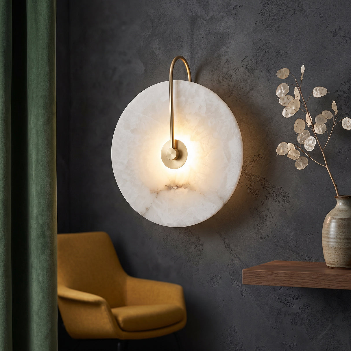 Round marble disc wall sconce lit on a dark grey plaster wall