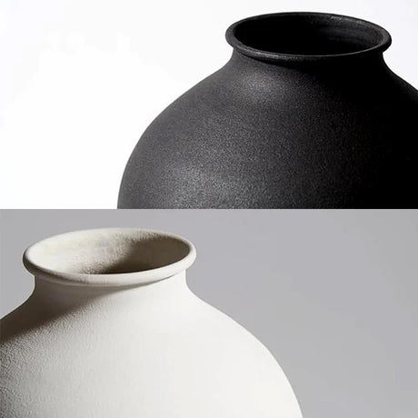 Sleek matte black round vase on table