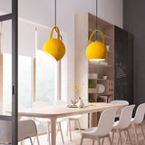 Metal ball pendant light hanging low over a neutral styled interior