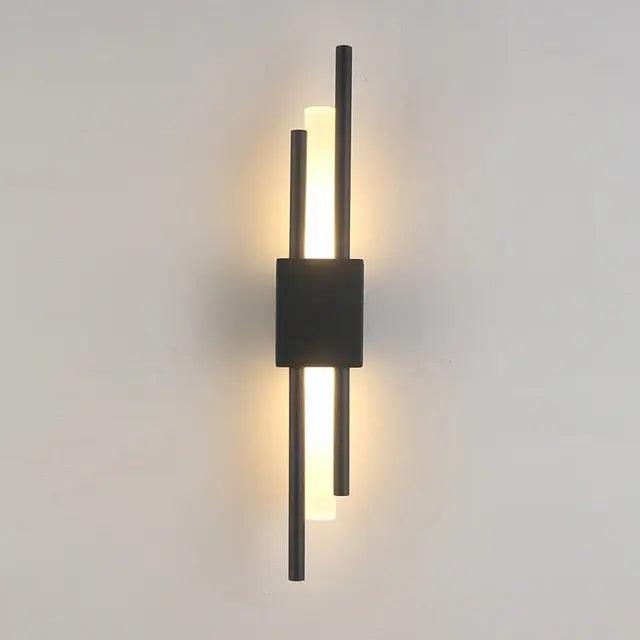 Matte black twin bar sconce lit against a plain grey background
