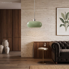 Green glass pendant light in a cosy living room with sofa and plant