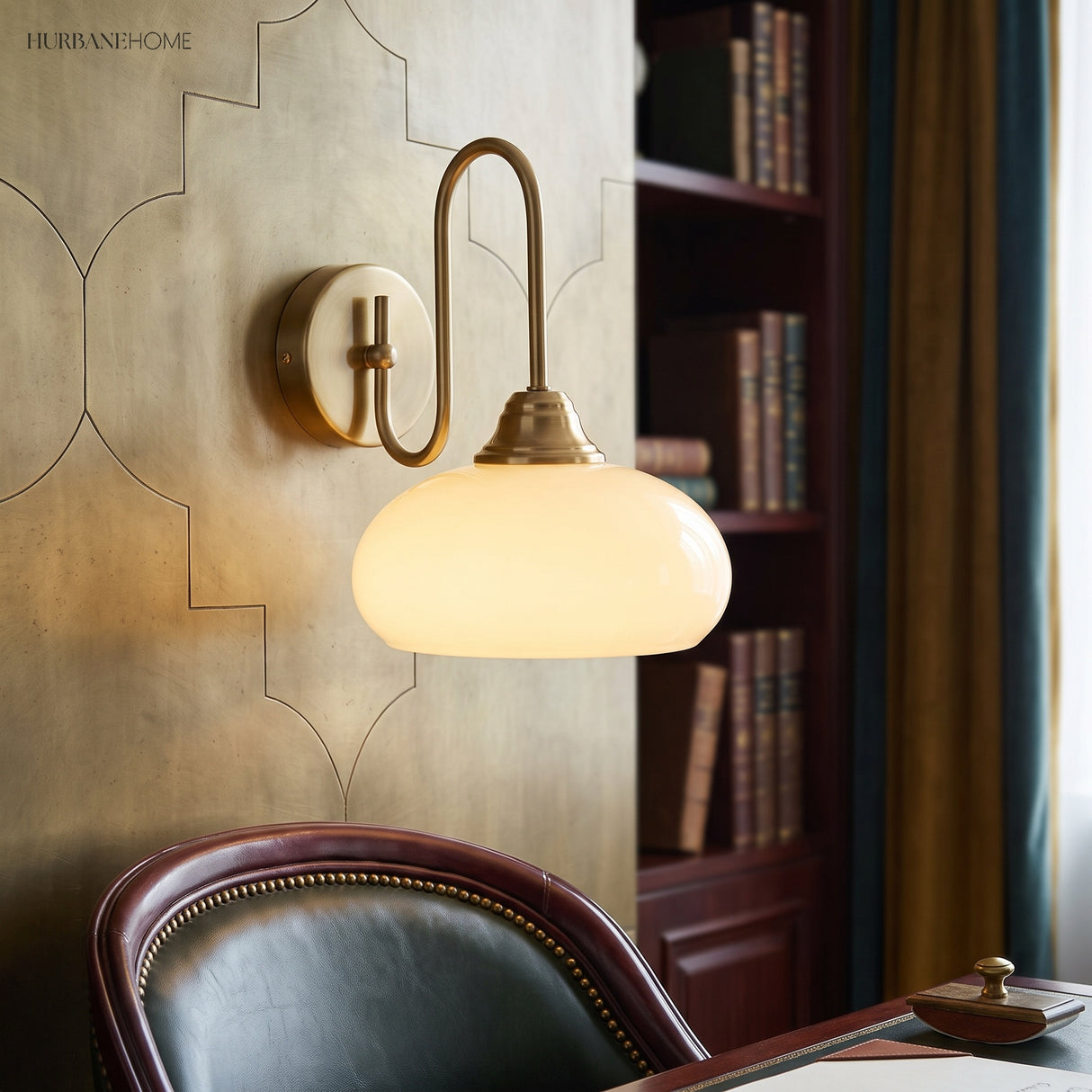 Copper curved wall sconce glowing above a study desk and leather chair