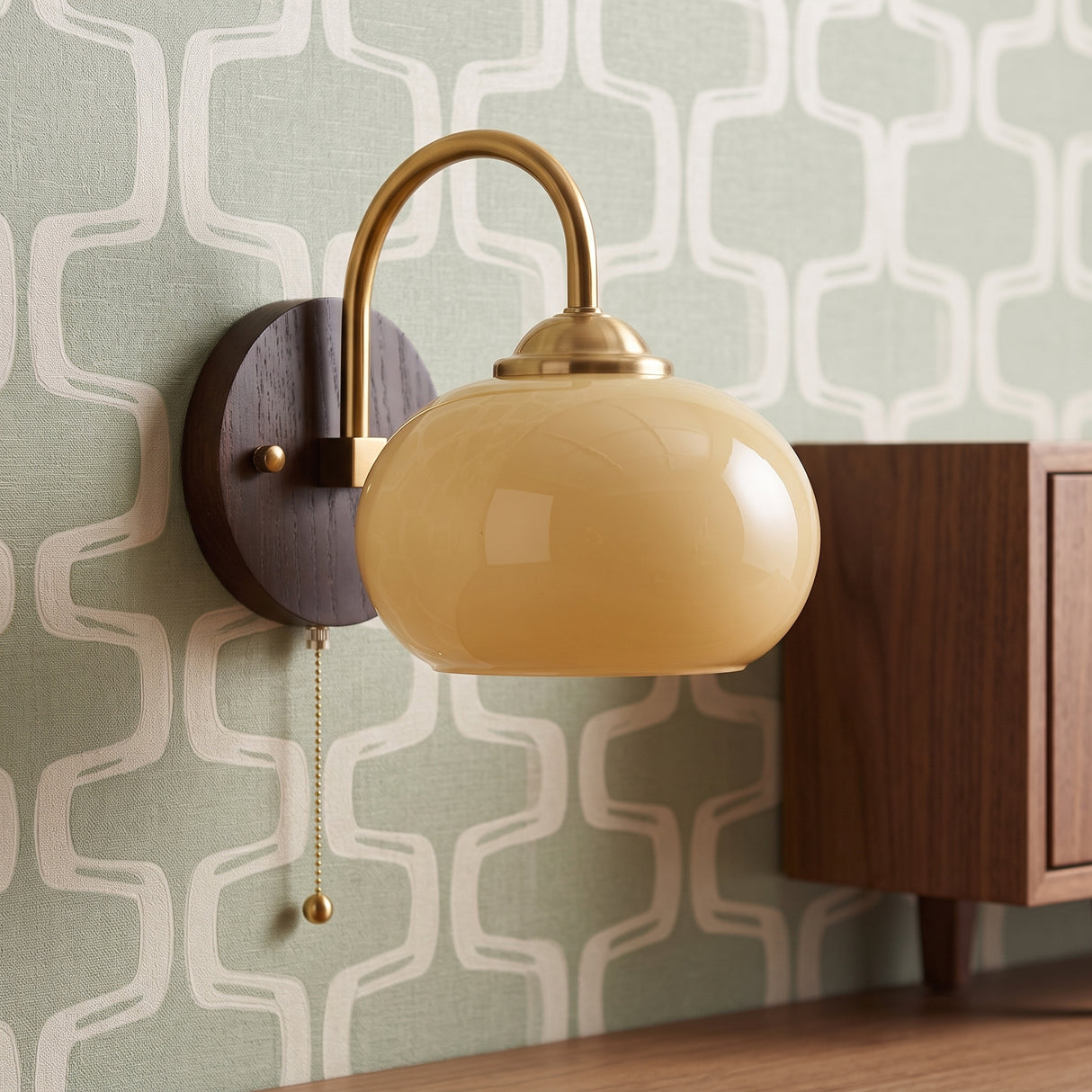 Cream glass sconce on ash wood backplate with retro patterned wallpaper