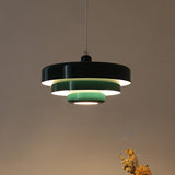 Black tiered pendant light with mint green inner rings, lit from within