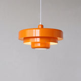 Orange mid century pendant light with three stepped metal tiers on a white cord