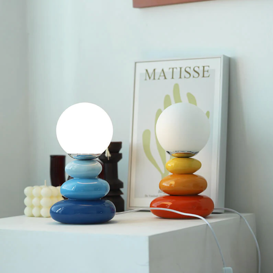 Blue and orange stacked lamps beside a framed leaf print