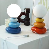 Blue and orange lamps lit either side of a dark wooden ornament