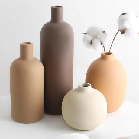 Mini ceramic vase set arranged on neutral shelf