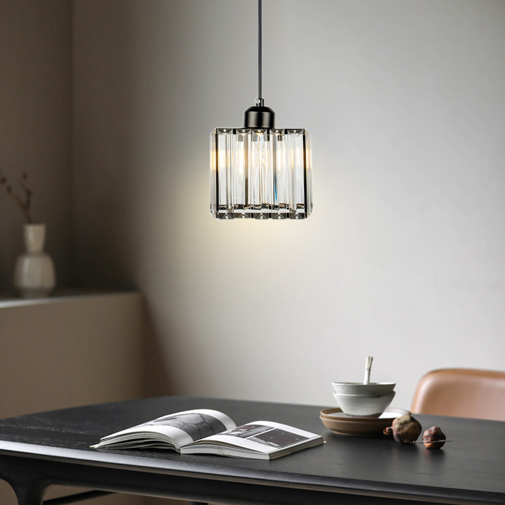 Small crystal pendant lighting an open book on a dark dining table