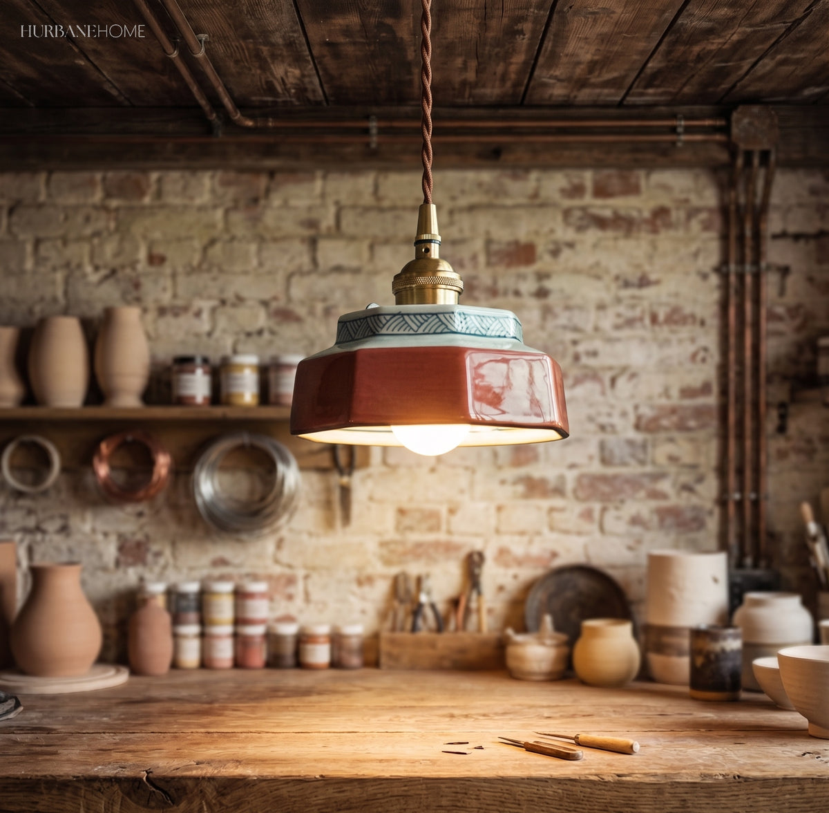 Teal ceramic pendant lit above a brick walled pottery bench