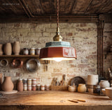 Teal ceramic pendant lit above a brick walled pottery bench