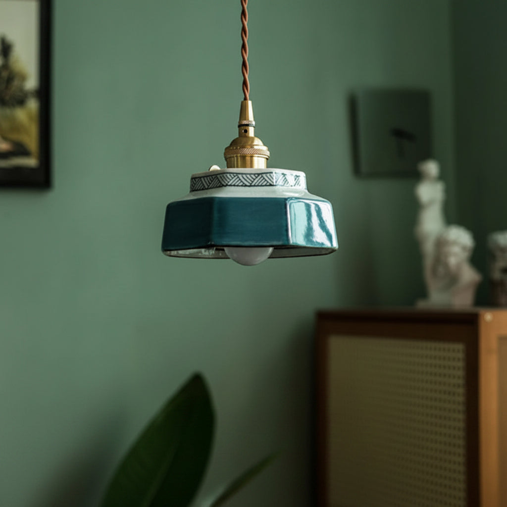 Teal ceramic pendant lit in a green room beside a cabinet