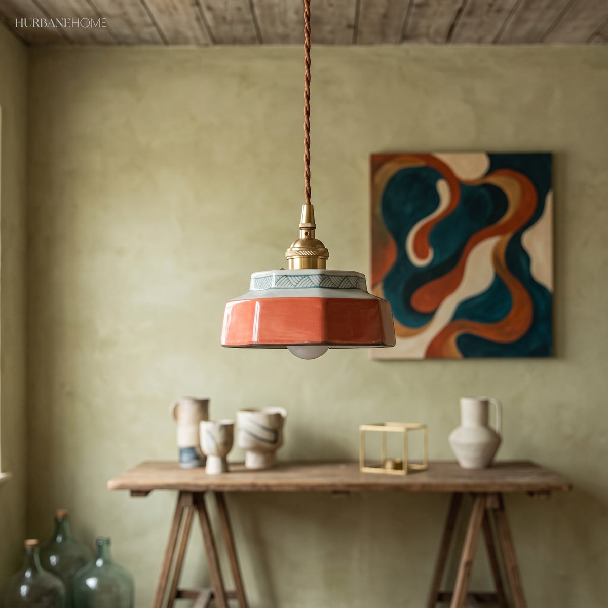 Terracotta ceramic pendant lit above a timber work table