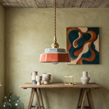 Terracotta ceramic pendant lit above a timber work table