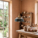 Teal ceramic pendant hung beside a window and a pottery shelf