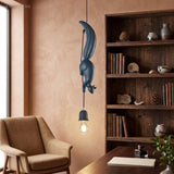 Blue squirrel pendant lit beside a bookcase and a leather chair