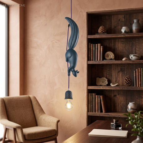 Blue squirrel pendant lit beside a bookcase and a leather chair