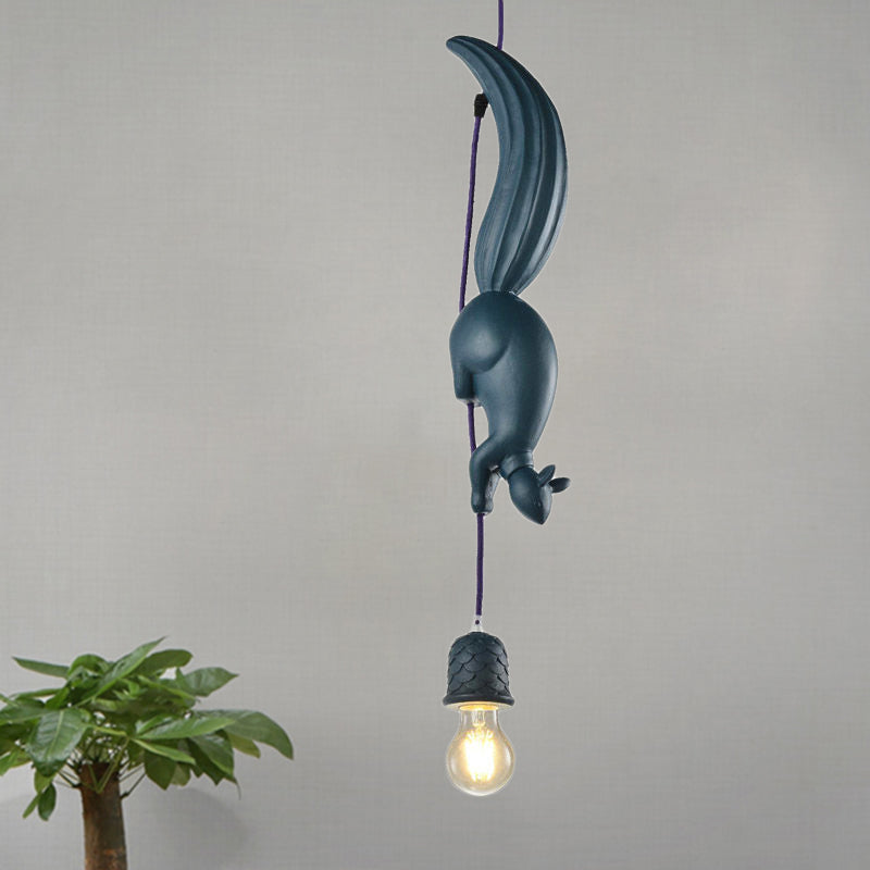 Blue squirrel pendant lit warm beside a tall potted plant