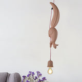 Pink squirrel pendant lit above a grey knitted throw and flowers