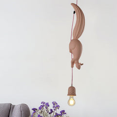 Pink squirrel pendant lit above a grey knitted throw and flowers