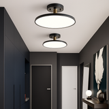 Two black disc lights lit in a dark panelled hallway