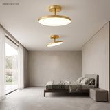 Gold disc ceiling lights lit in a bedroom beside tall windows