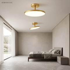Gold disc ceiling lights lit in a bedroom beside tall windows