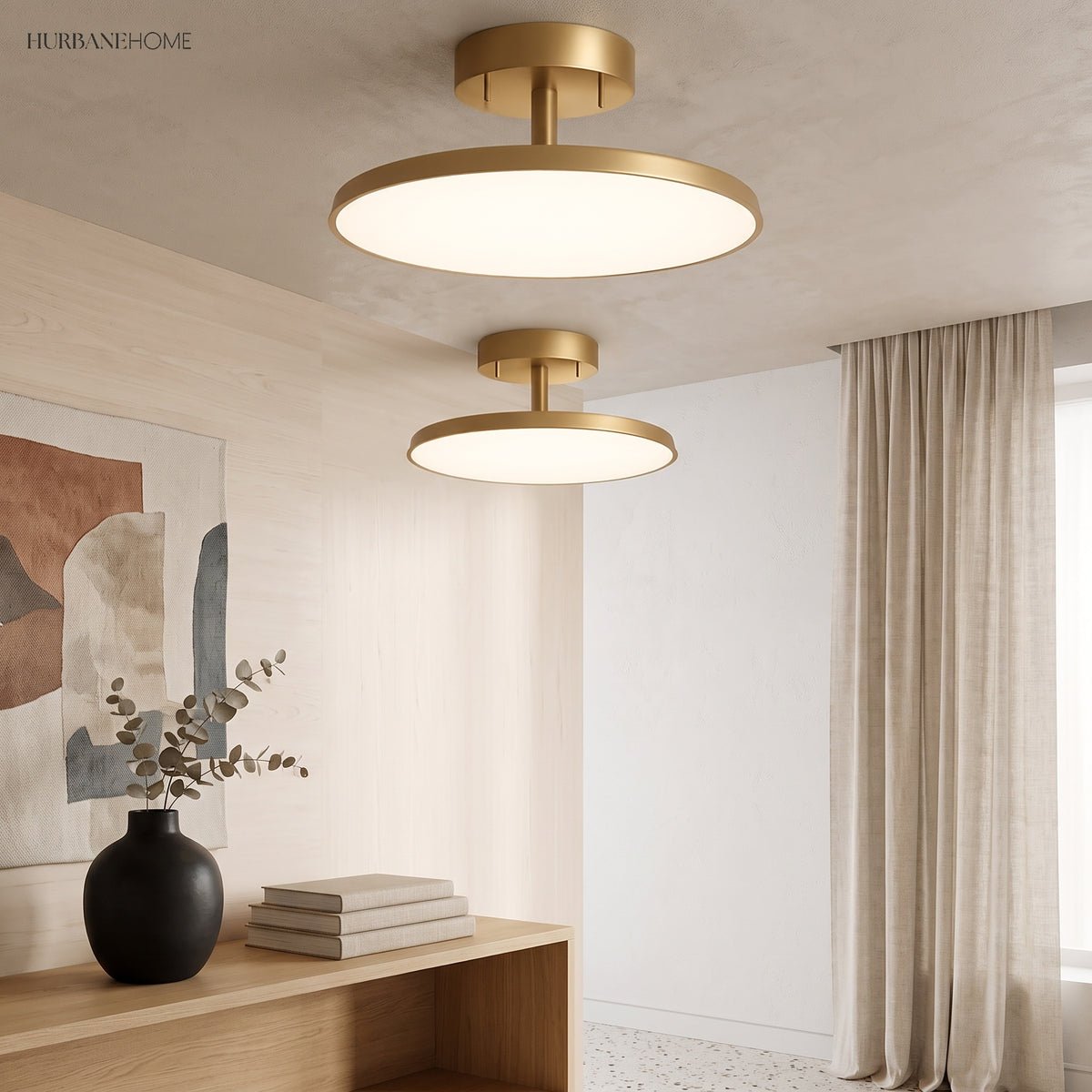 Two gold disc ceiling lights lit above a console and artwork