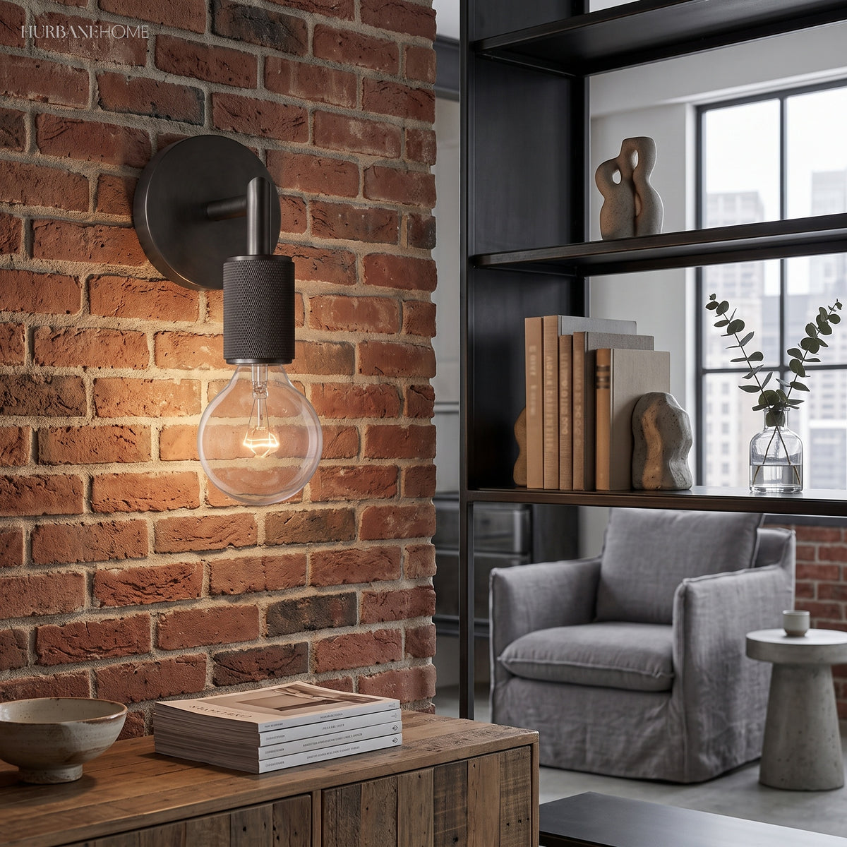 Black bare bulb sconce mounted on exposed brick in a loft room