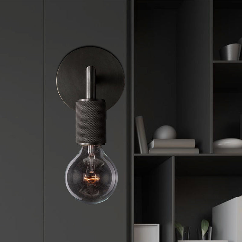 Black sconce on a dark gray wall beside open shelving