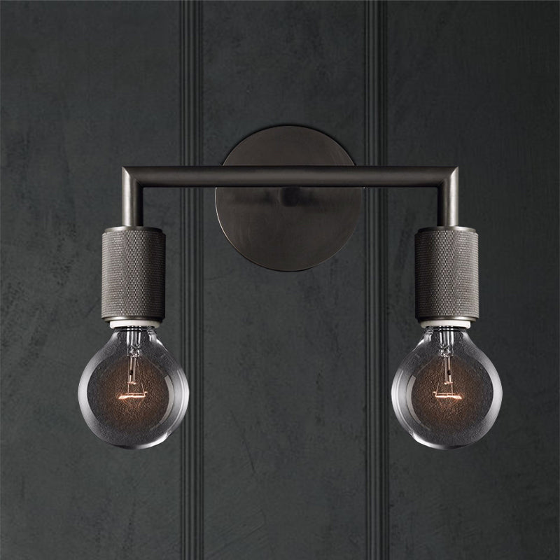 Two light black sconce on a dark paneled wall lit warm
