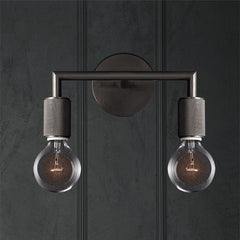 Two light black sconce on a dark paneled wall lit warm