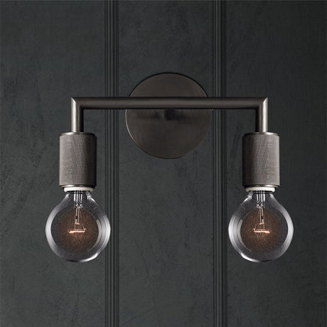 Two light black sconce on a dark paneled wall lit warm