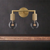 Two light brass sconce lit warm above a floating timber shelf