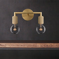Two light brass sconce lit warm above a floating timber shelf