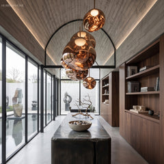 Row of mirrored molten pendants hung along a timber lined corridor