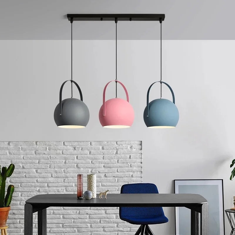 Muted grey ball pendant light against a soft neutral background