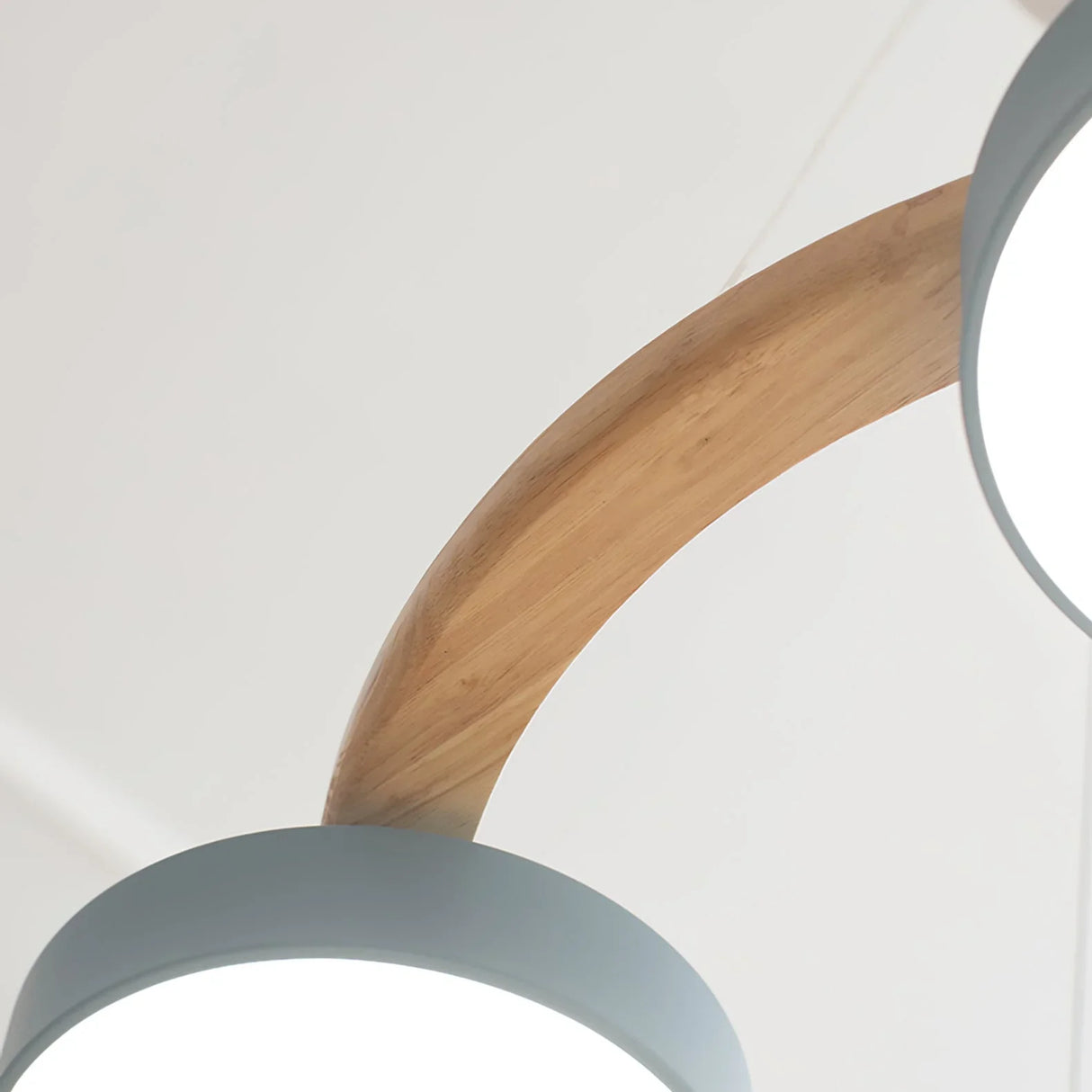 Modern bird chandelier with a round wooden frame and evenly spaced drum shades