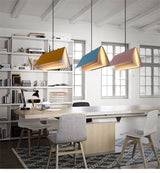 Yellow blue and pink book pendant lights above a home office desk